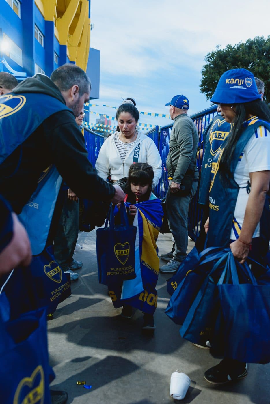 Integrantes de la murga con sus capas azules y doradas caminando entre la gente