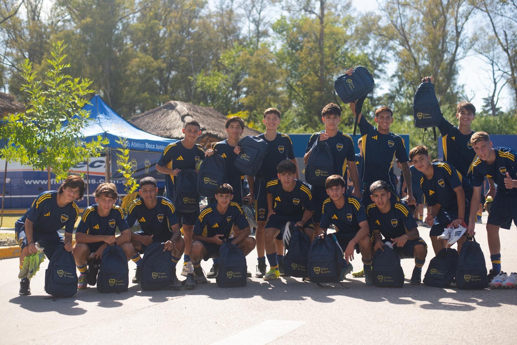 Grupo de chicos y chicas posando al aire libre con las mochilas entregadas por la Fundación
