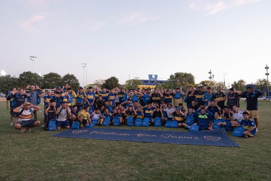 Grupo numeroso de chicos y chicas reunidos en una cancha al aire libre durante una jornada de la Fundación