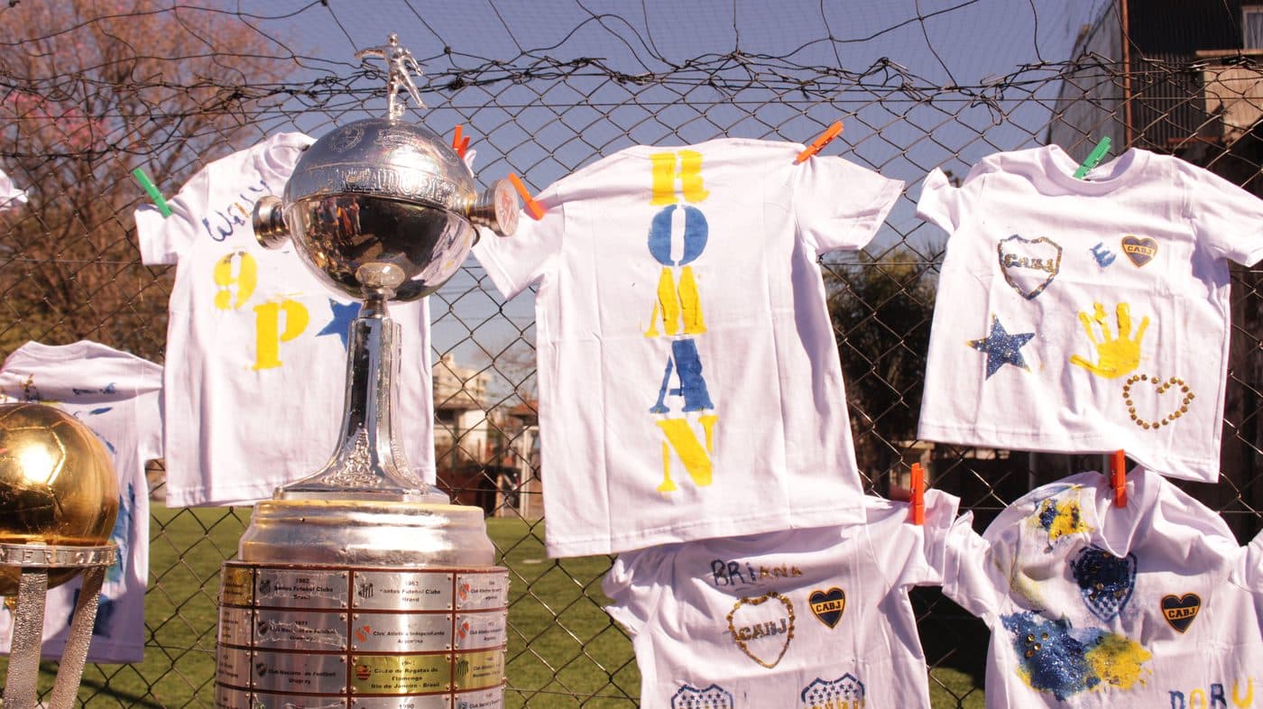 Las camisetas terminadas colgadas del alambrado, con la Copa Libertadores delante