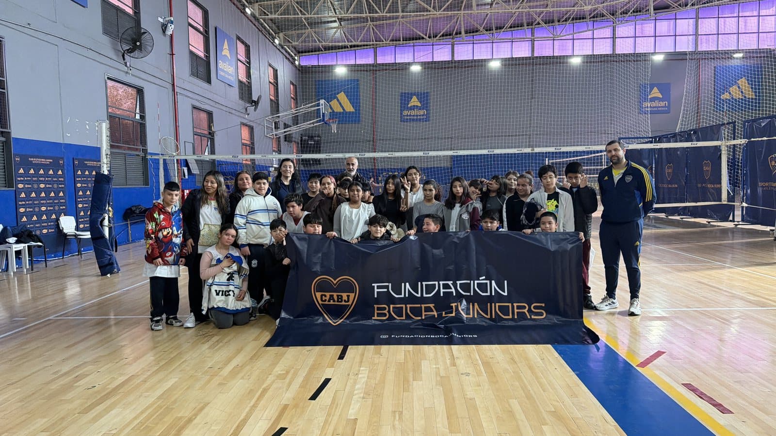 Grupo de participantes posando con la bandera de la Fundación Boca Juniors al final de una jornada