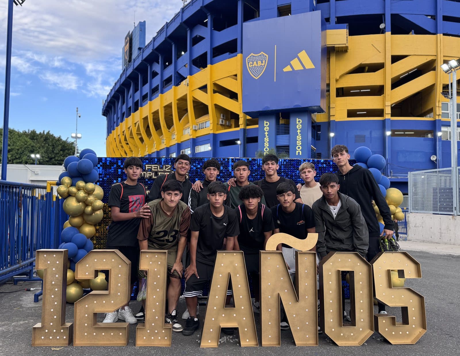 Grupo de hinchas posando junto a las letras de “121 años” en el corredor de acceso al estadio