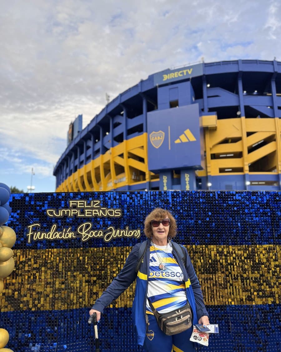 Una hincha posa frente a la Bombonera decorada con globos azules y dorados por el aniversario del club